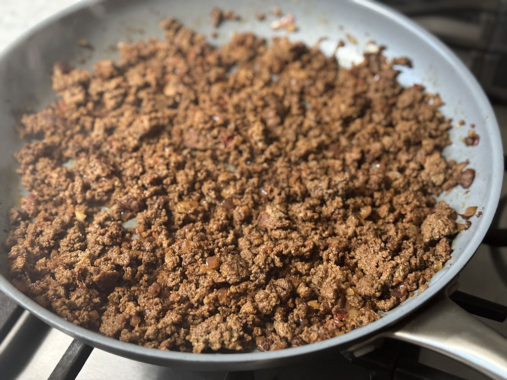 Taco seasoned cooked ground beef in a skillet.