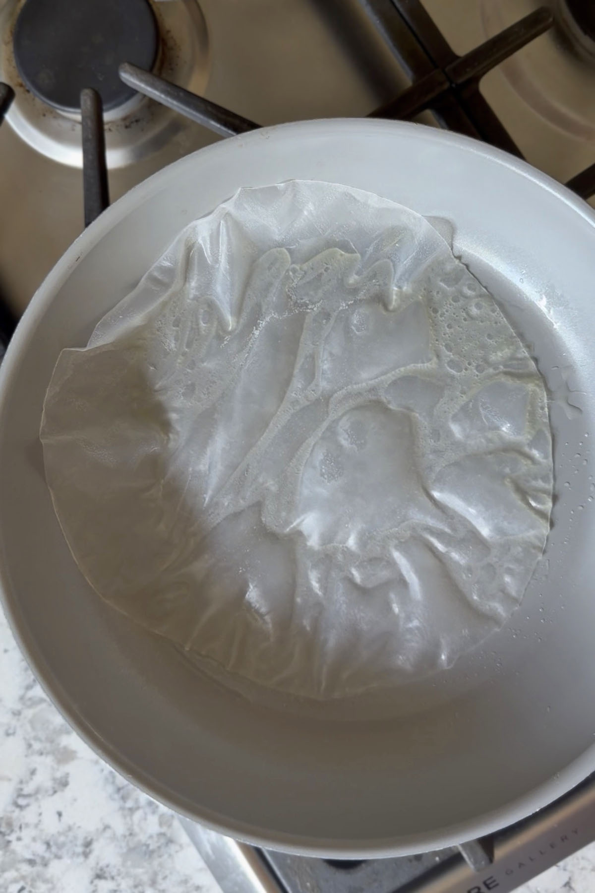 Softened sheet of rice paper in a skillet.