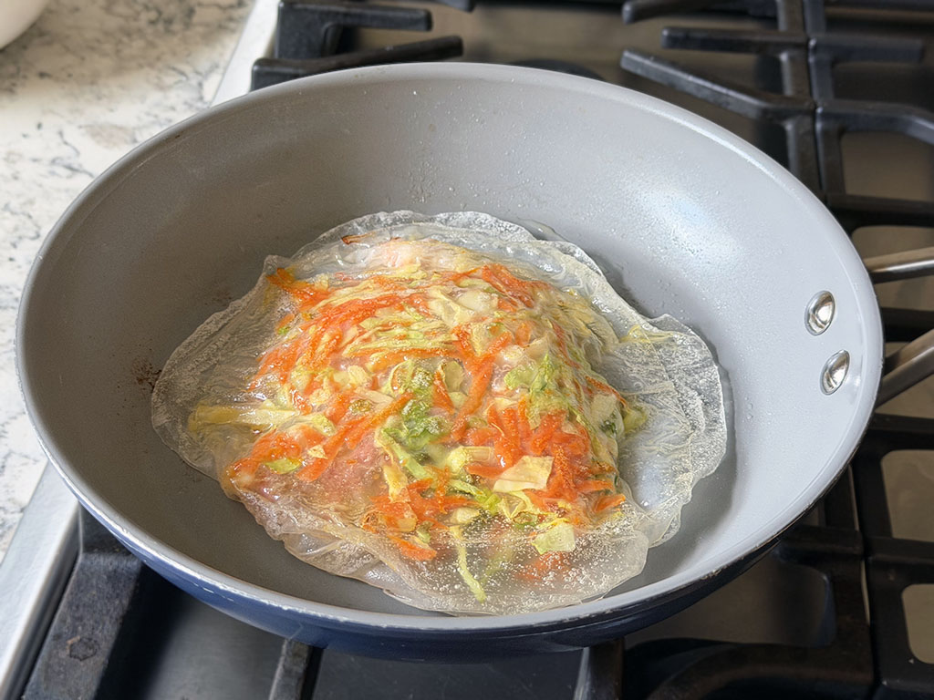 Rice paper sheet filled with veggies and topped another rice paper sheet to form a pancake.