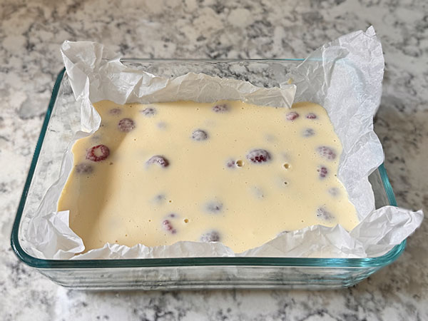 Baked yogurt batter in a baking dish lined with parchment paper.