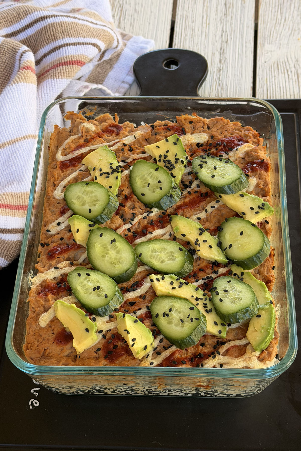 Easy canned tuna sushi bake served with avocado, cucumber, and sesame seeds on top, ready to enjoy.
