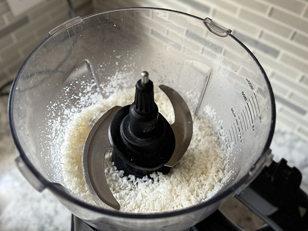 Fine texture coconut in a food processor bowl.