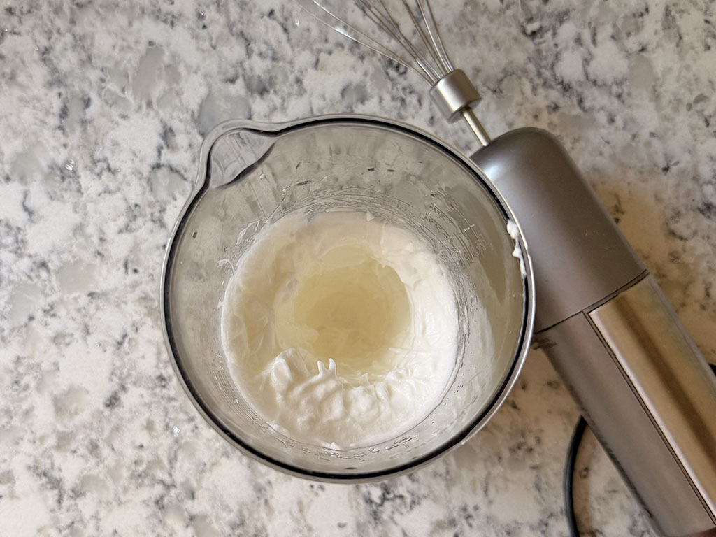 Egg whites beaten with an electric mixer until glossy medium peaks form.
