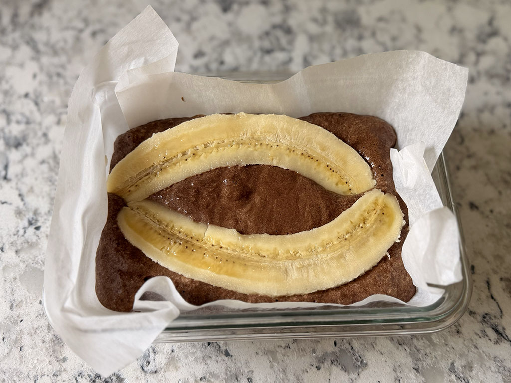 Banana halves placed cut-side up on chocolate batter and gently pressed into the surface.