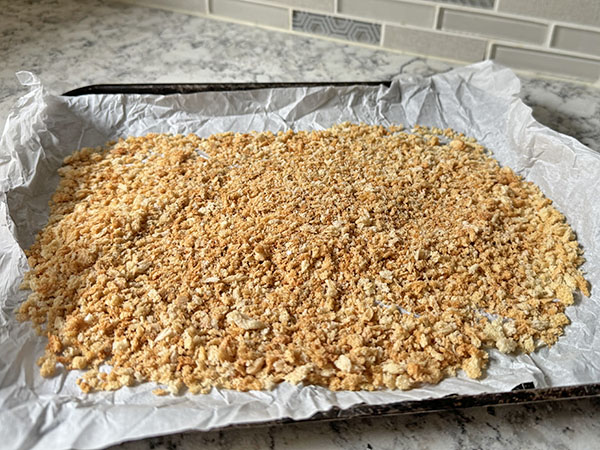 Toasted panko breadcrumbs on a baking sheet, mixed with seasonings.