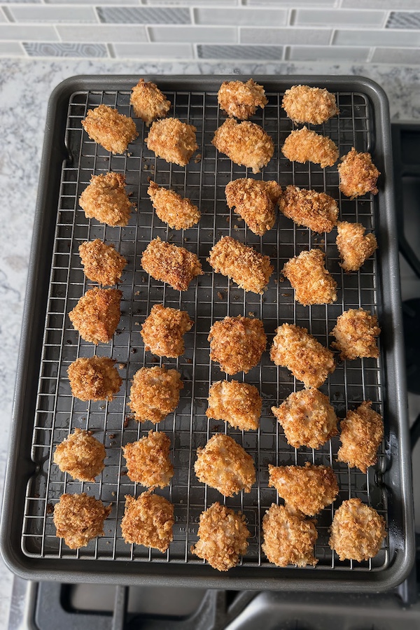 Baked homemade panko chicken nuggets resting on a wire rack.