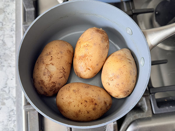 Boiled potatoes drained in a pot.