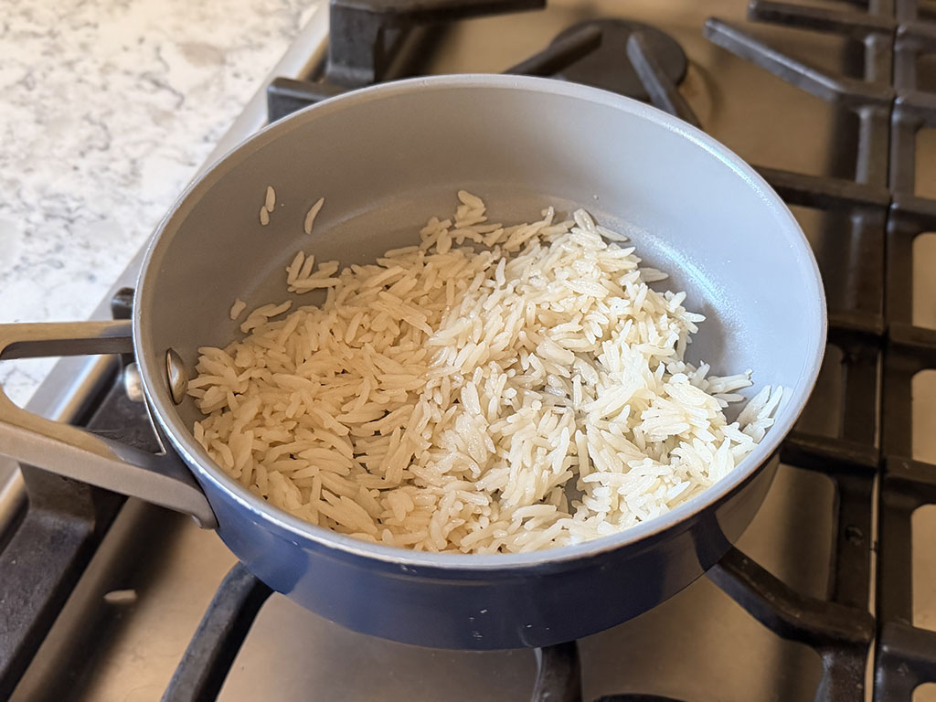 Sushi rice cooking in a saucepan on the stovetop.