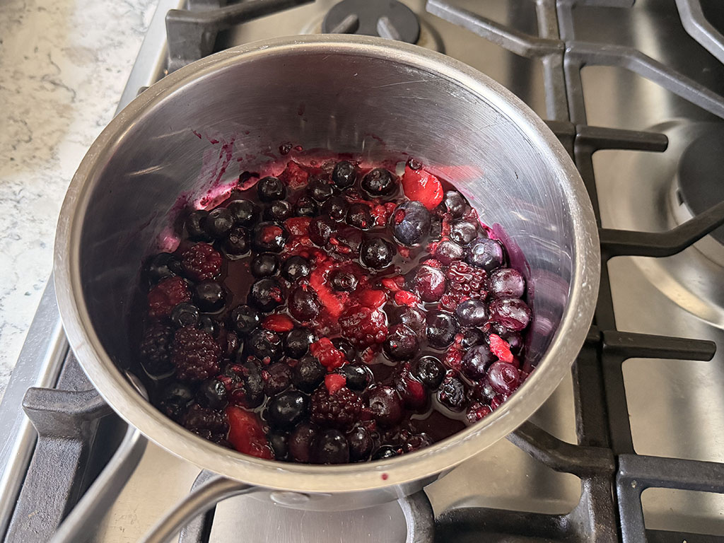Frozen berries cooking in a saucepan.