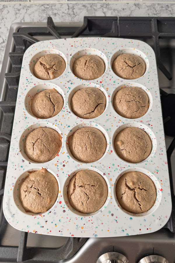 Baked Gluten Free Banana Oat Muffins cooling in a silicone muffin tin.