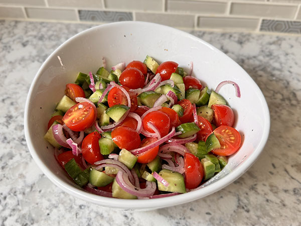 Fresh salad with tomatoes, cucumbers and onion in a bowl.