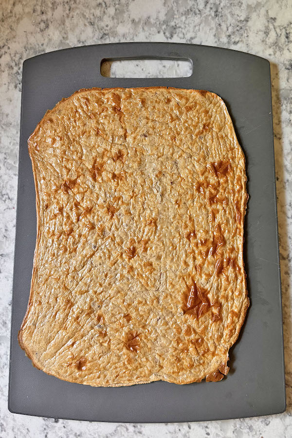 Lightly brown baked cottage cheese wrap on a baking sheet.