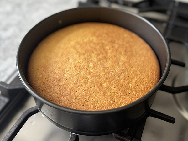 Baked golden-brown orange cake straight from the oven.