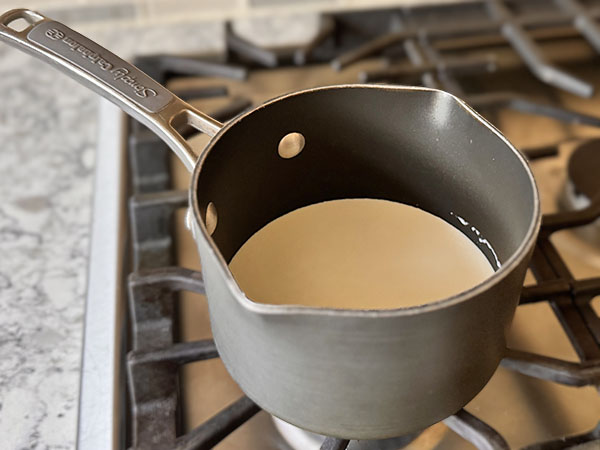 Heavy cream in a saucepan on the stovetop.