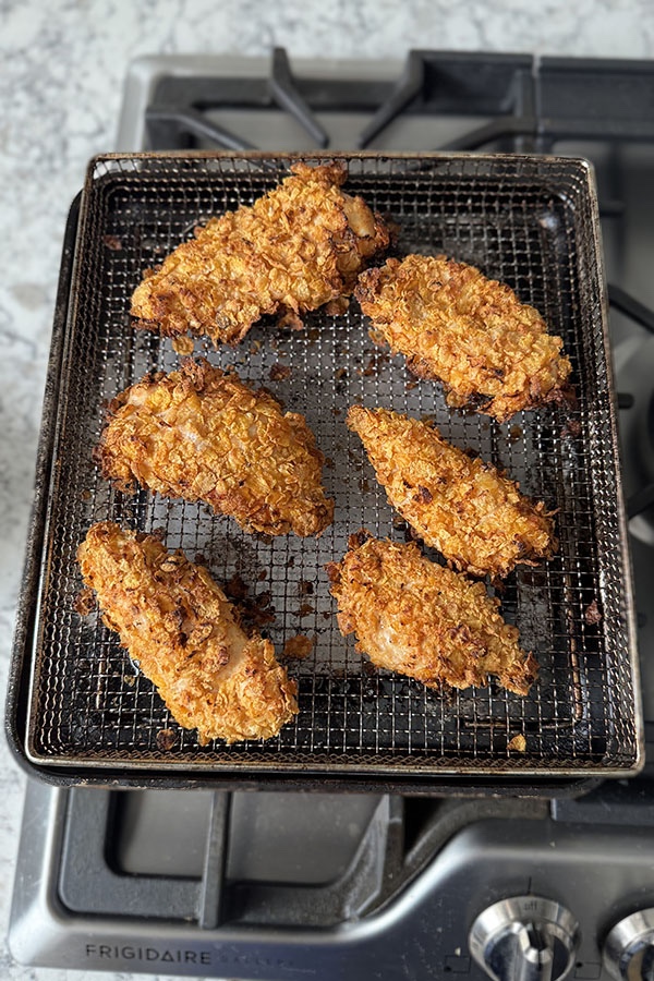 Baked crispy cornflake chicken on a wire rack.