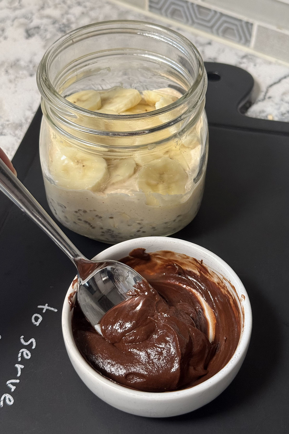 Greek yogurt mixed with melted chocolate in a small bowl for the chocolate layer.