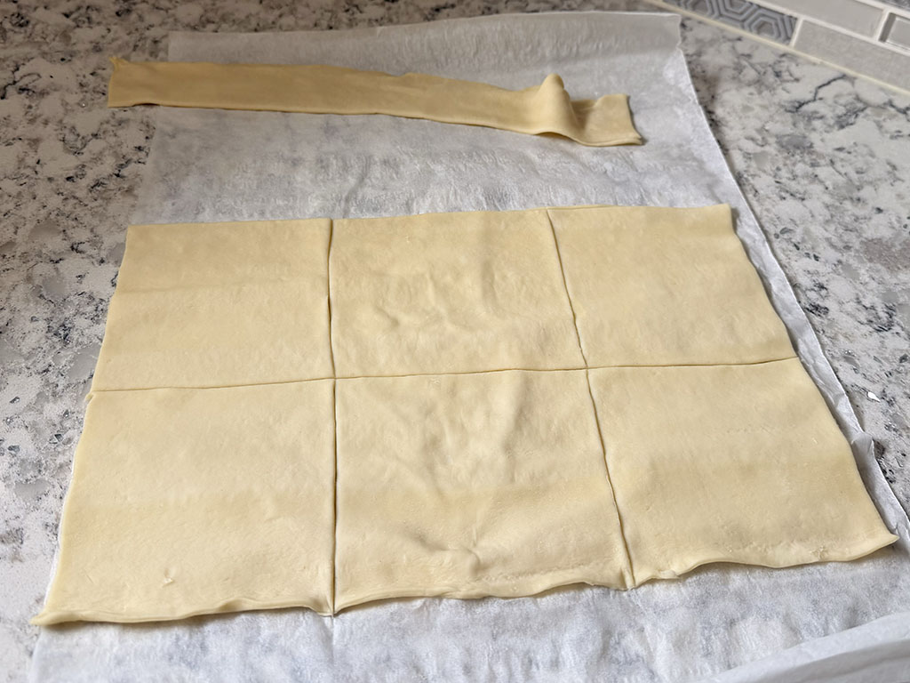 Лист слоёного теста разрезан на шесть одинаковых квадратов.
