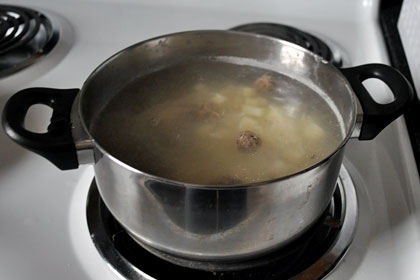 Pot of Russian meatball soup cooking on stove top.