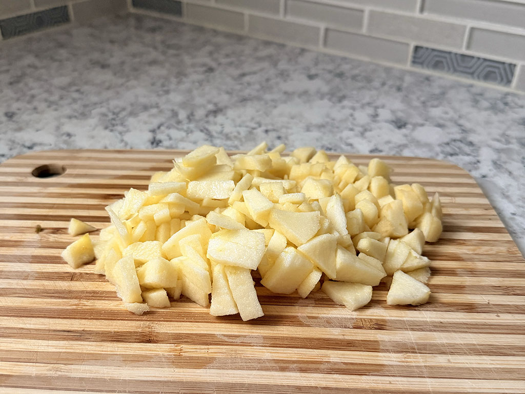 Finely diced apples on a cutting board.