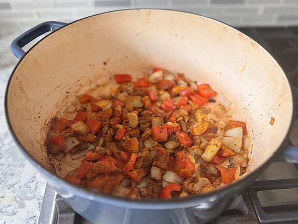 Curry vegetables and fragrant spices cooking in a Dutch oven.